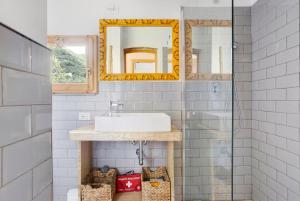 W łazience znajduje się umywalka i lustro. w obiekcie Villino Marco w mieście Luni