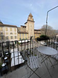 einen Tisch und Stühle auf einem Balkon mit einem Gebäude in der Unterkunft Piazza Mascheroni Home in Bergamo