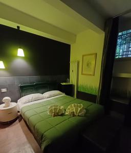 - une chambre avec un lit vert et 2 oreillers dans l'établissement Il Giardino del Viaggiatore, à Rome