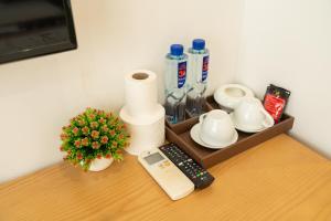 a shelf with a remote control and a flower on a table at Korea 2 Hotel Bac Giang in Làng Thành