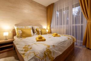 利托斯基簡的住宿－Apartmán Petruša，一间卧室配有一张大床,床上配有黄色毛巾