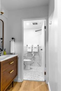 a white bathroom with a toilet and a shower at King Bed, The Phenix Historic Hotel, Spacious, Room # 406 in Bangor