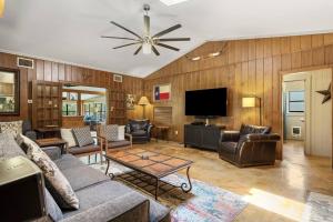 a living room with a couch and a tv at Riverfront home on 40 acres w firepit, hot tub in Wimberley