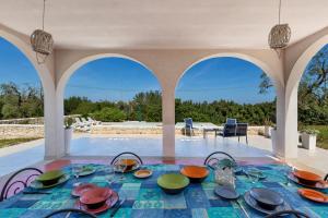 a table with bowls and plates on it in a pavilion at Villa Sierri by Perle di Puglia in Specchiolla 