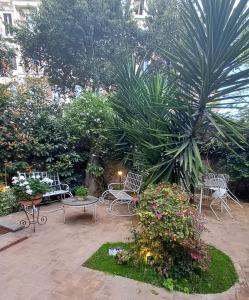 un patio con sedie, tavoli e piante di Il Giardino del Viaggiatore a Roma