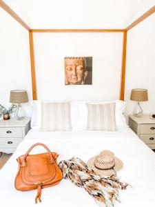 torebkę i kapelusz na łóżku w obiekcie DIX Restaurant & Chambres d'hotes w mieście Saint-Alvère