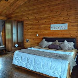 a bedroom with a large bed in a wooden room at Hotel Cabañas y Mirador Secret Garden CR in Cartago