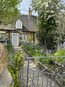Casa de piedra con puerta blanca y jardín en Remarkable Cotswolds 1 bedroom cottage in Finstock, 
