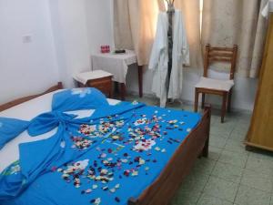 Una cama con una manta azul con flores. en Hotel de la plage, en Bizerte