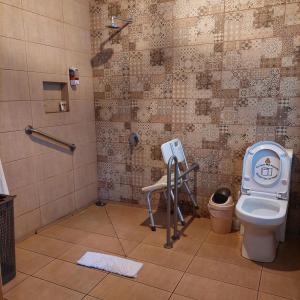 a bathroom with a toilet and a shower with a phone at Hotel Cabañas y Mirador Secret Garden CR in Cartago