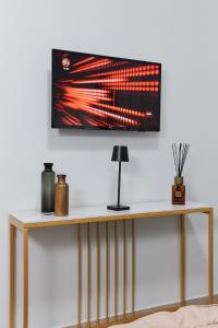 a television hanging on a wall above a table at Showroom Luxury B&B in Reggio Calabria