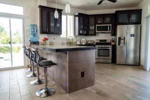 a kitchen with stainless steel appliances and a large island at La Vida Perezosa in Caye Caulker