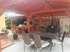 een patio met een tafel en stoelen en een keuken bij Farkas Apartmanok in Balatonlelle