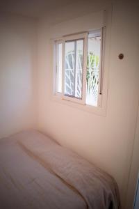 een witte kamer met een raam en een bed bij Casa Ander: Cozy and Bright Vacation Bungalow in San Fulgencio