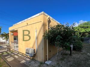 um pequeno edifício com a letra b sobre ele em コテージマリンロード em Fukai