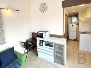 a small kitchen with a microwave on a counter at コテージマリンロード in Fukai
