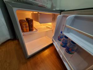 um frigorífico aberto com garrafas de água e leite em Dodo Home 3 em Hanói