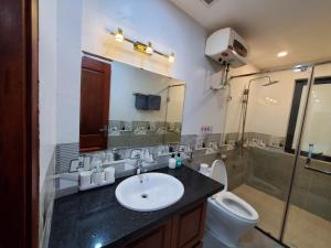a bathroom with a sink and a toilet and a shower at Dodo Home 3 in Hanoi
