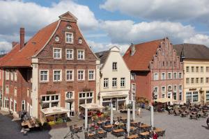 a group of buildings in a city with tables at Fereinwohnung am Marktplatz in Warendorf