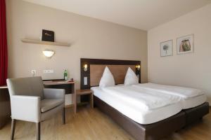 ein Hotelzimmer mit einem Bett und einem Stuhl in der Unterkunft Hotel Moseldomizil in Mülheim an der Mosel