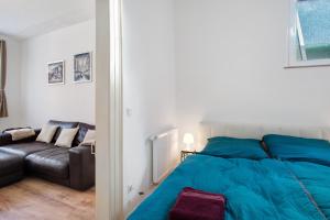 a bedroom with a blue bed and a couch at Fereinwohnung am Marktplatz in Warendorf