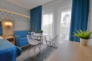 una camera d'albergo con letto, tavolo e sedie di Apartamenty Cesarskie - Apartamenty Bryza - Parking a Świnoujście