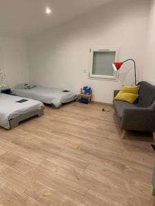 salon z 2 łóżkami i kanapą w obiekcie Superbe Villa Centre-ville Millau w mieście Millau