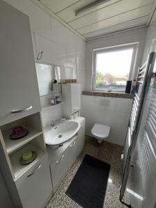 a white bathroom with a sink and a toilet at Nordseestern in Holtgast