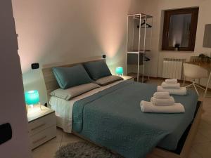 ティヴォリ・テルメにあるAppartamento Tivoli Terme Petite Maisonのタオルが敷かれた大きなベッドのある寝室