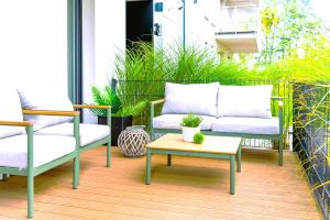 eine Terrasse mit einem Sofa, einem Tisch und Stühlen in der Unterkunft Marina Apartment in Iława