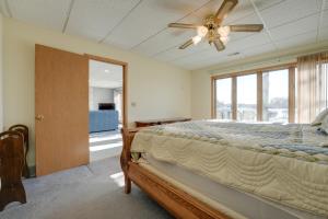 - une chambre avec un lit et un ventilateur de plafond dans l'établissement Lakeside Michigan Retreat with Boat Dock and Fireplace, à Woodland Beach