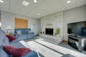 Una sala de estar con un sofá azul y un televisor. en Lakeside Michigan Retreat with Boat Dock and Fireplace, en Woodland Beach