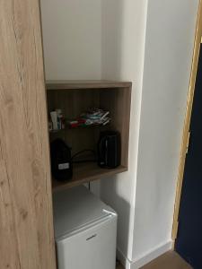 a bathroom with a shelf above a white refrigerator at casa serao in Naples