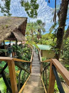 a wooden walkway leading to a resort with a bridge at Biohotel Arara River in Leticia