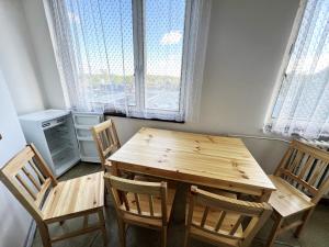 drewniany stół i krzesła w pokoju z oknami w obiekcie Hotel Penzion Rohožník w Pradze
