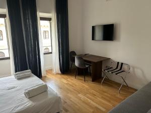 una camera d'albergo con una scrivania e un letto di casa serao a Napoli