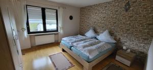 a bedroom with a brick wall and a bed at Haus Maria in NeuhÃ¼tten +2 photos