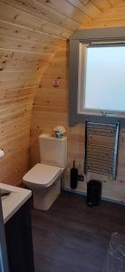a bathroom with a toilet in a wooden wall at Neptune's Rest in Fort William