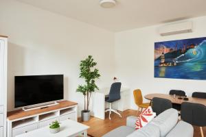 sala de estar con TV y mesa en New Spacious Ultra-Modern Apartment in Wien Westbahnhof en Viena
