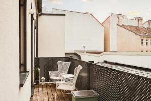 a balcony with two chairs and a trash can at New Spacious Ultra-Modern Apartment in Wien Westbahnhof in Vienna
