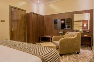 una camera d'albergo con letto, scrivania e sedia di نور الشرق a Dammam