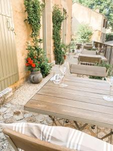 una mesa de madera con copas de vino en el patio en DIX Restaurant & Chambres d'hotes, en Saint-Alvère