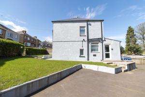 a white building with a grass yard in front of it at Contractor Base Newport 3 Bed Van Parking Sleeps 5 in Newport
