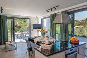 a kitchen and living room with a table and chairs at Villa Ilianthi in Kalamitsi