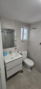 y baño con aseo blanco y lavamanos. en Apartamento Maestra, en Jaén