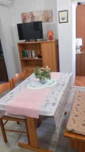 a dining room table with a flower arrangement on it at Apartments Pinezić in Martinšćica