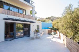 a patio with chairs and a table on a house at Villa Ilianthi in Kalamitsi