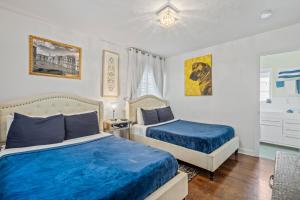 1 dormitorio con 2 camas y sábanas azules en villa venezia bb en Miami Beach