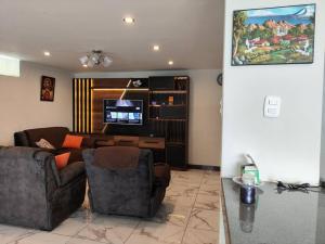 a living room with a couch and a tv at Warm House Near the Airport Callao in Lima