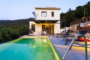 a villa with a swimming pool and a house at Villa Ilianthi in Kalamitsi